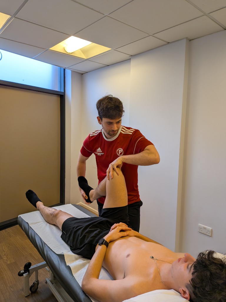 Matthew Knight performing a knee assessment on a patient